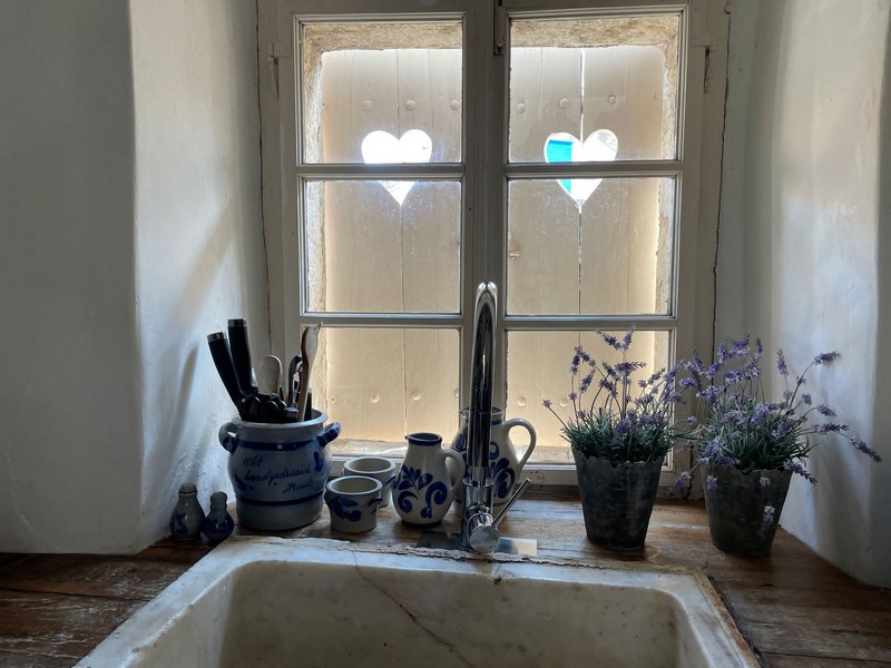 Blick vom Waschbecken auf den Fensterladen mit ausgestanztem Herz.