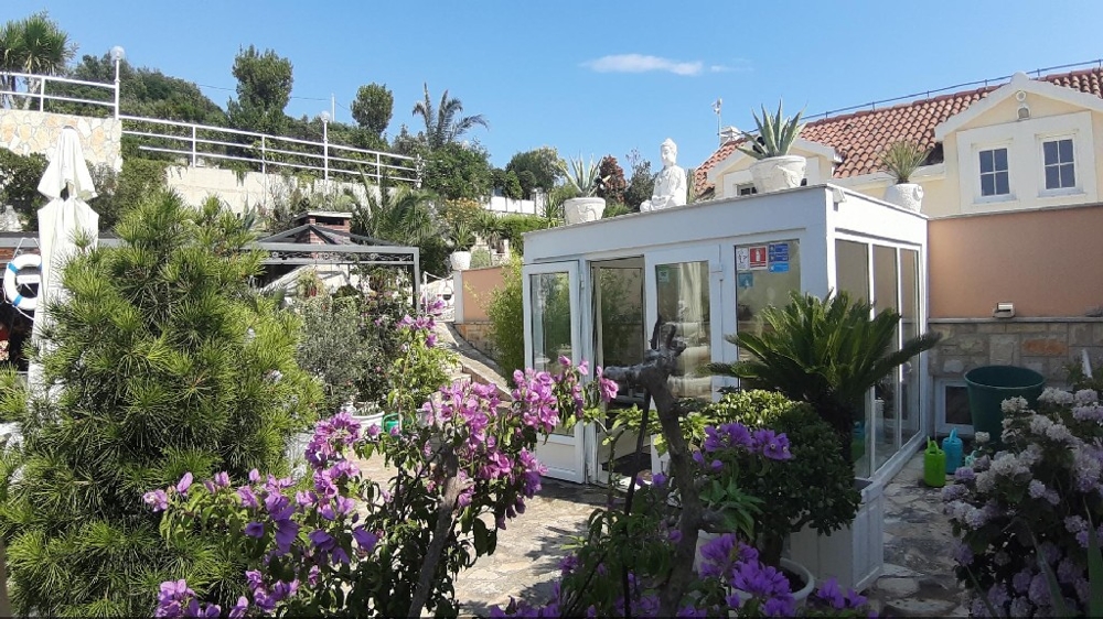 Sicht vom Garten auf eine überdachten Außenbereich der Villa in Mittel Dalmatien.
