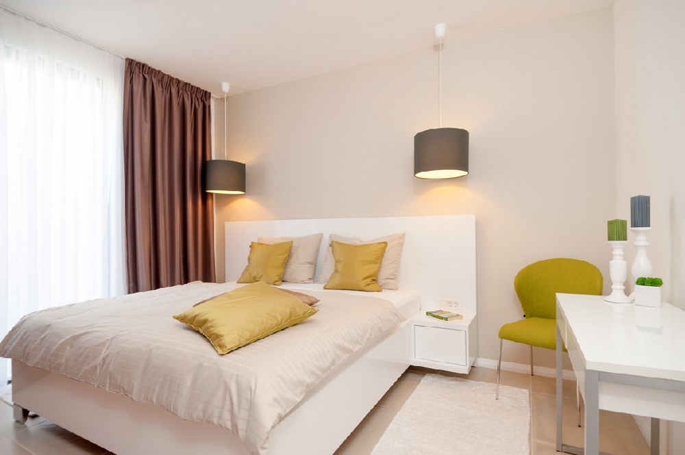 Ein Schlafzimmer mit Doppelbett und Fenster der Immobilie - Haus kaufen Kroatien.