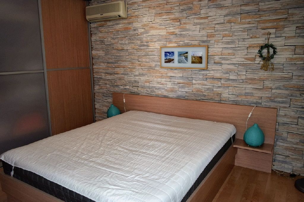 Blick in das Schlafzimmer mit Klimatisierung und traditioneller Stein-Fassade.