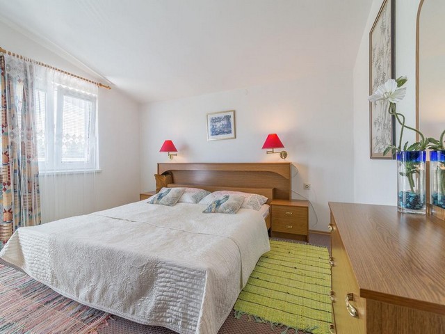 Ein helles Schlafzimmer mit Doppelbett und Fenster in der Region Zadar.