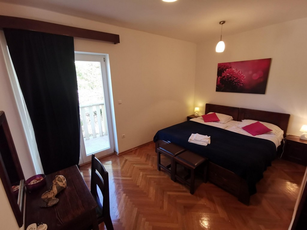 Ein Schlafzimmer der Immobilie mit einem Doppelbett und Ausgang zum Balkon - Haus kaufen Kroatien.