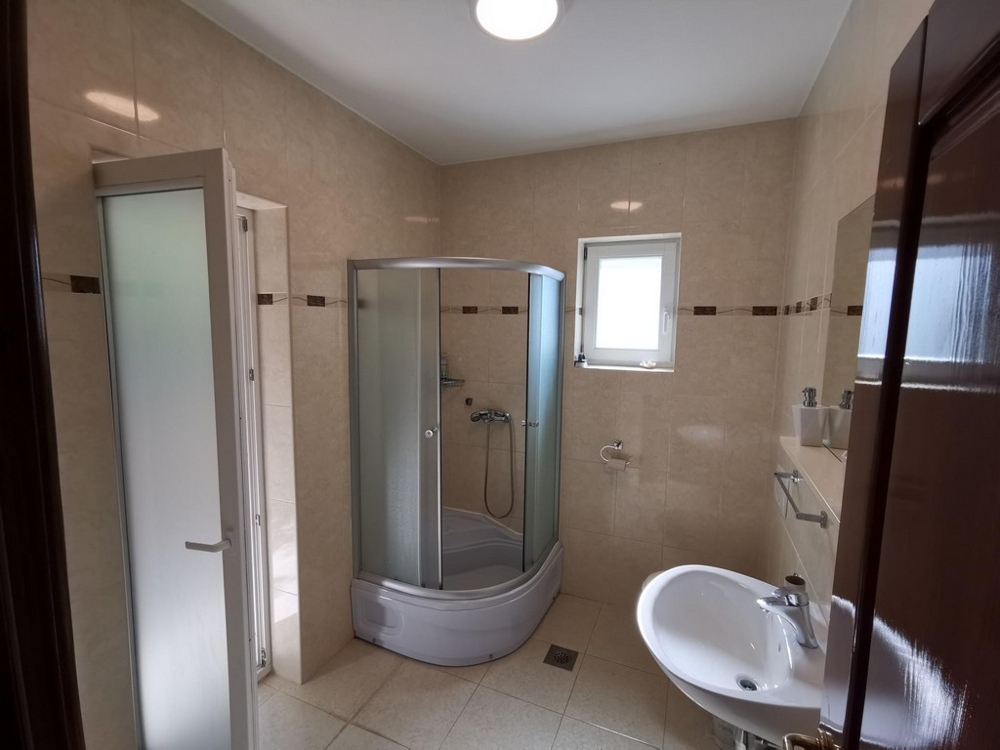 Ein Badezimmer der Immobilie H1557 mit Dusche, WC und Fenster in der Kvaner Bucht.