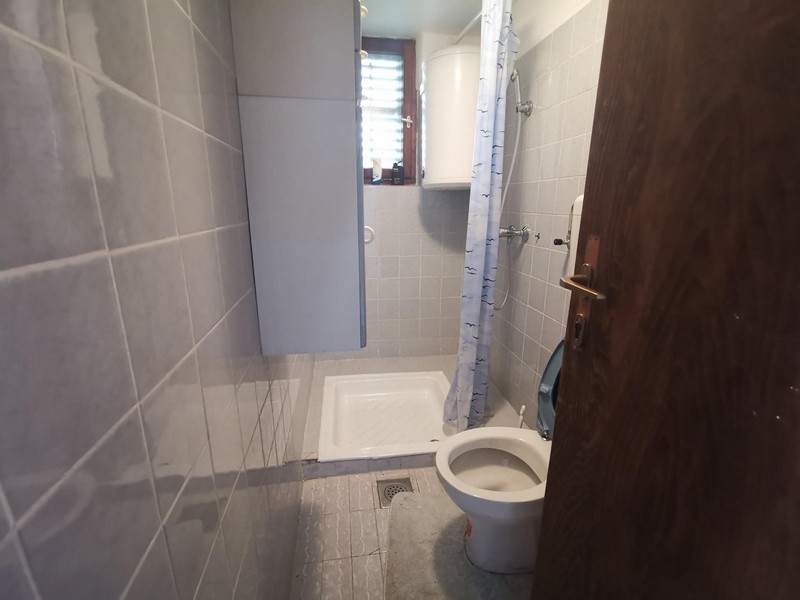 Ein Badezimmer mit WC, Dusche und Fenster der Immobilie H1559 - Panorama Scouting.