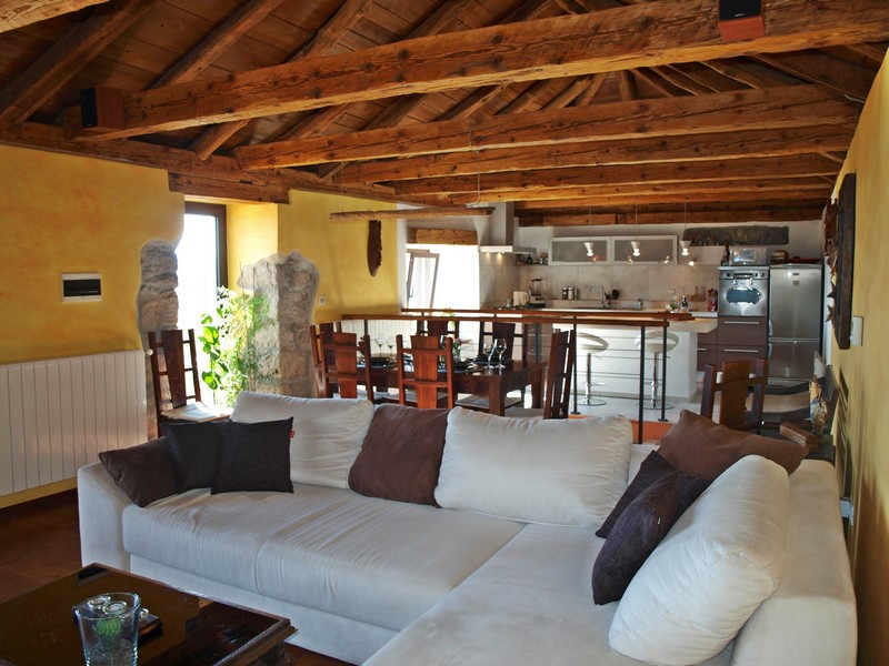 Sicht auf den offenen Wohnraum mit Essbereich und Küche im Obergeschoss der Immobilie.