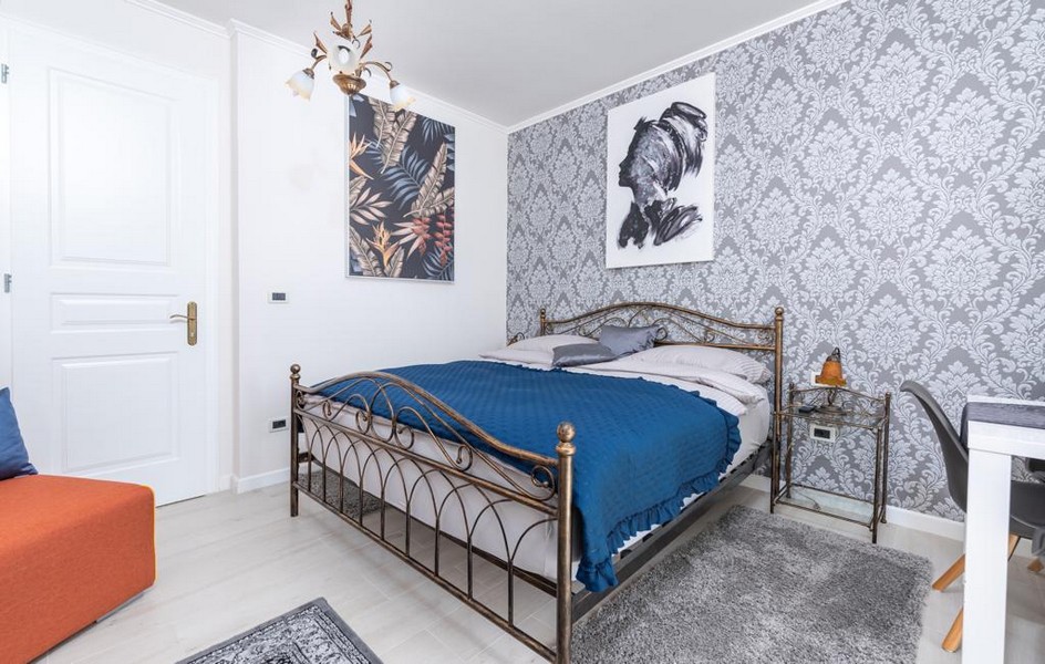 Schlafzimmer mit Doppelbett und dekorativer Tapete in einer Luxusvilla in Istrien zum Verkauf.