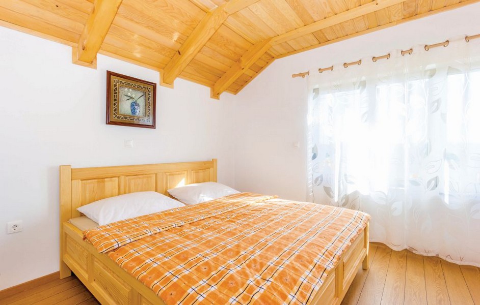 Gemütliches Doppelbett im Landhaus-Stil im Dachgeschoss der Immobilie H2249 in Senj, Kroatien - Panorama Scouting.
