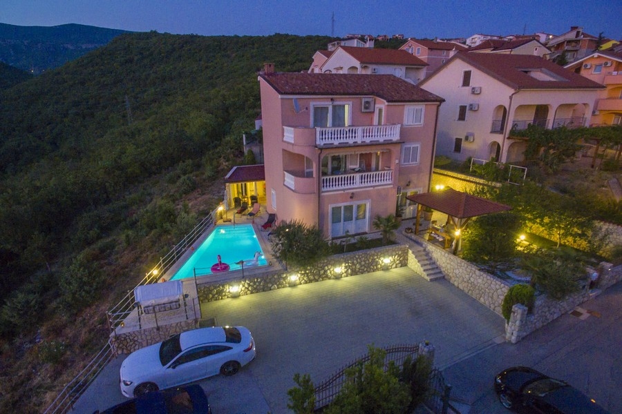 Abendansicht eines Mehrparteienhauses am Meer in Kroatien mit beleuchtetem Pool - Immobilien Kroatien