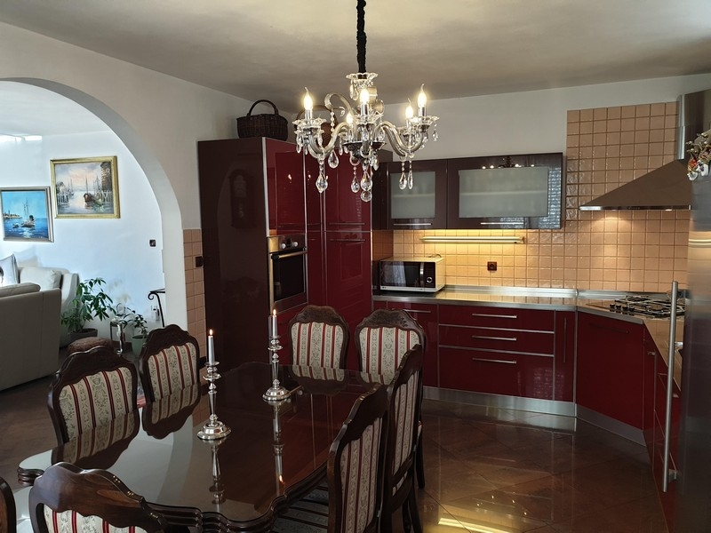 Elegantes Esszimmer mit rotbrauner Küche in einem Mehrparteienhaus in Kroatien