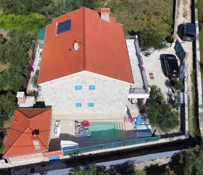 Luftaufnahme eines zum Verkauf stehenden Steinhauses in Kroatien, mit Garten und Pool.
