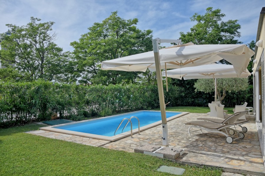 Haus in Istrien kaufen, mit privatem Pool und Blick auf üppiges Grün.
