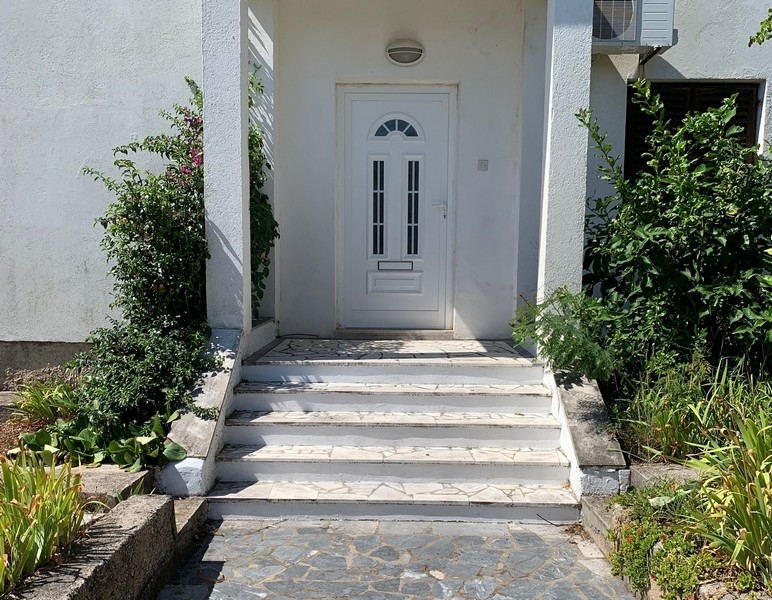 Eingangsbereich des Hauses in Kroatien mit weißer Tür und Steinstufen