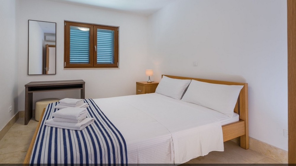 Ein Schlafzimmer der Immobilie A1706 mit Doppelbett in Kroatien.