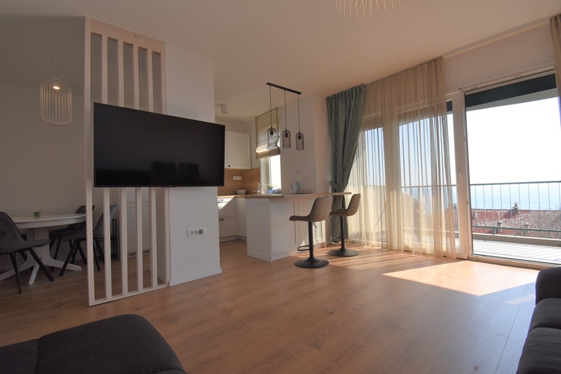 Modern eingerichtetes Wohnzimmer mit Panorama-Meerblick.