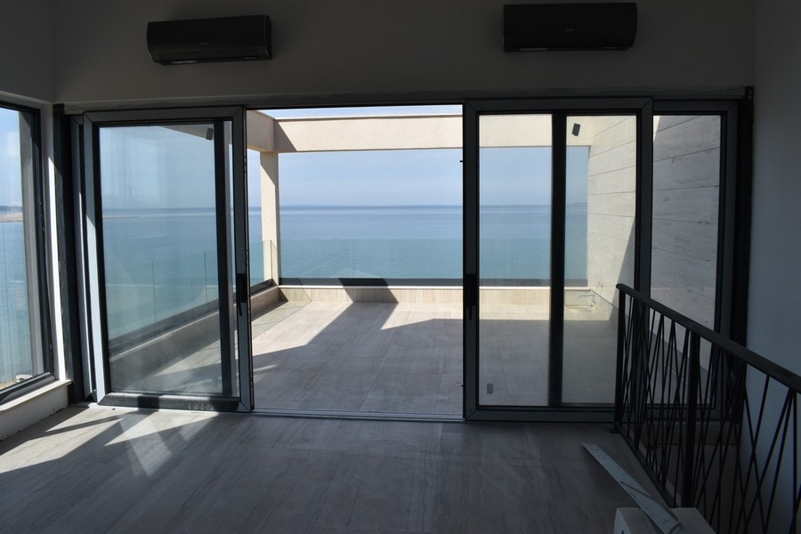Blick vom klimatisierten Wohnzimmer auf die Terrasse und das Meer. 
