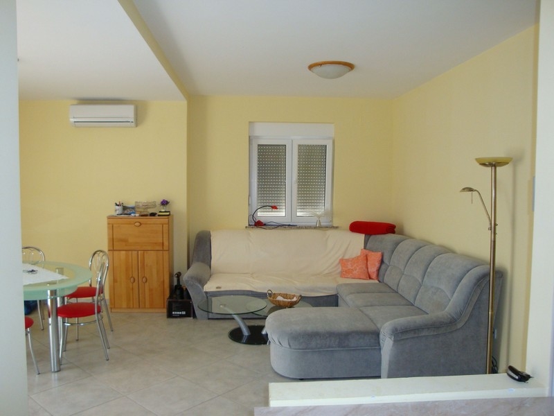 Wohnzimmer mit grauer Couch und Klimaanlage.