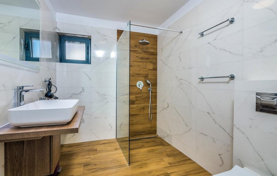Modernes Badezimmer mit ebenerdiger Dusche in Holzoptik.