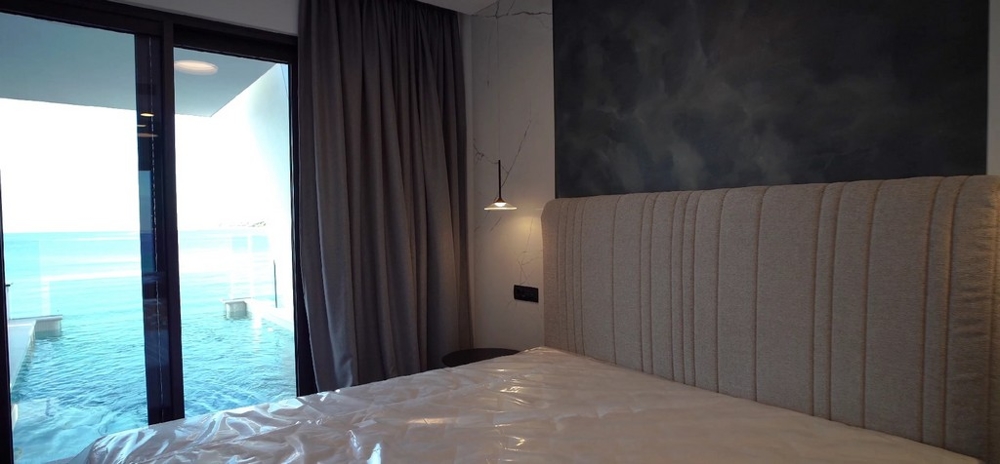 Schlafzimmer in einer luxuriösen Wohnung am Meer in Kroatien mit direktem Blick auf das adriatische Meer und stilvollem, gepolstertem Kopfteil
