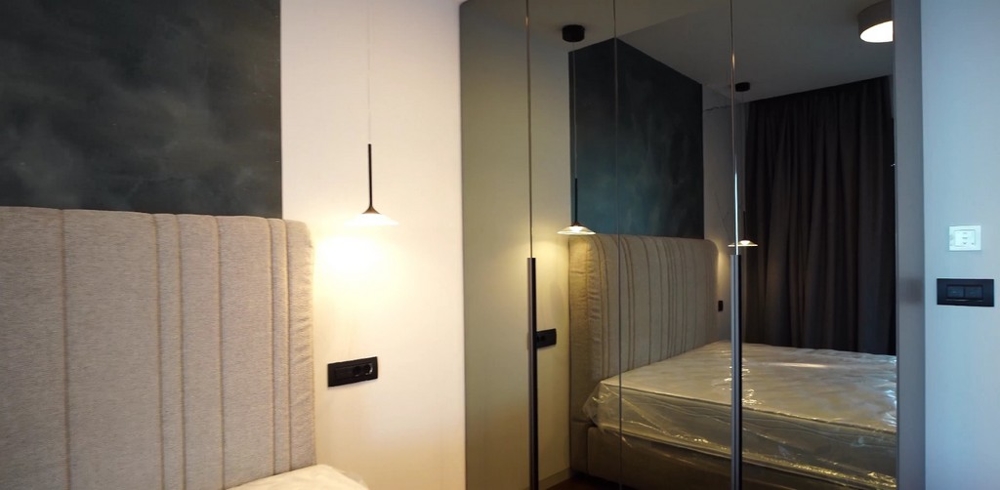 Elegantes Schlafzimmer in einer Immobilie am Meer Kroatien, mit spiegelnden Schranktüren und harmonischer Beleuchtung, die eine ruhige Atmosphäre schafft