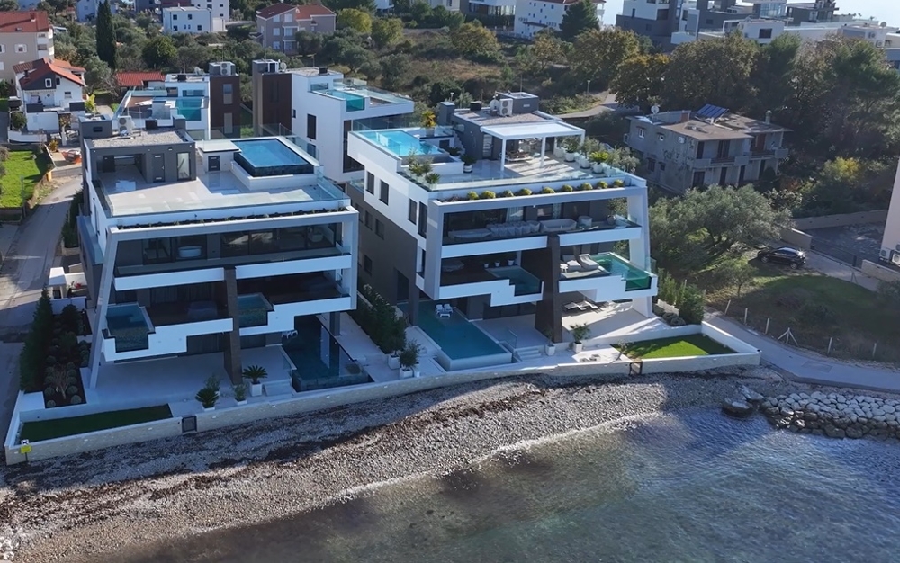 Drohnenansicht einer luxuriösen Immobilienanlage am Meer in Kroatien mit direktem Strandzugang.