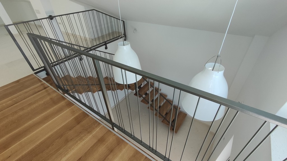 Penthouse kaufen Kroatien - Moderne Penthouse-Galerie mit schlichten Metallgeländern und weißen Designerleuchten, mit Blick auf das elegante Treppenhaus, verfügbar über Panorama Scouting.