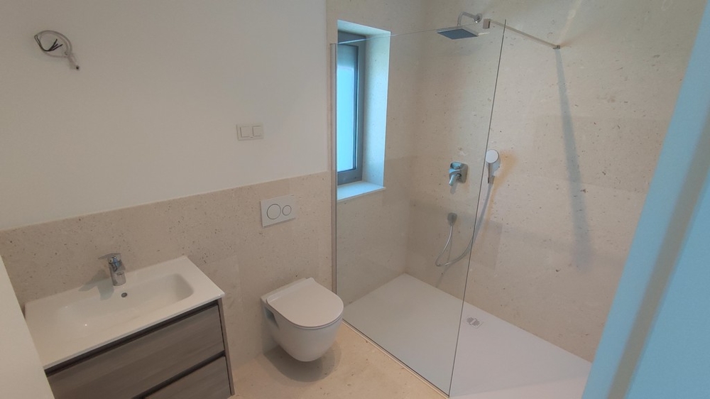 Penthouse kaufen Kroatien - Modern ausgestattetes Badezimmer im Penthouse mit begehbarer Dusche und eleganten Fliesen, angeboten von Panorama Scouting
