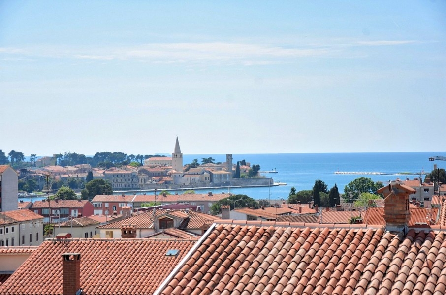 Blick über Terrakotta-Dächer auf das Adriatische Meer von einem zum Verkauf stehenden Penthouse in Istrien.