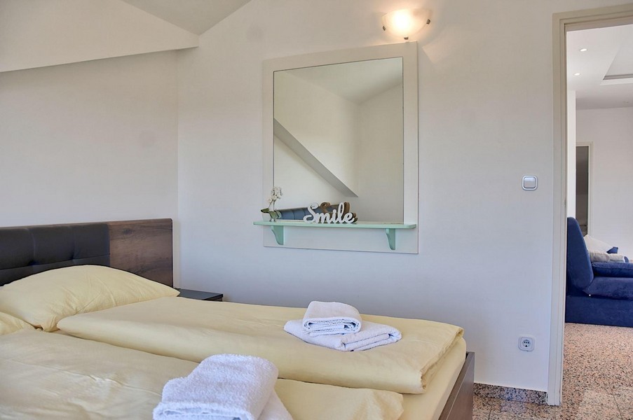 Schlafzimmer mit Doppelbett und Spiegel in einer Wohnung in Istrien