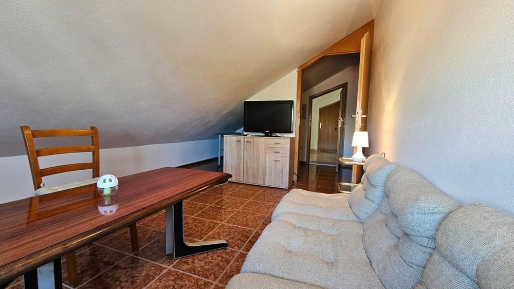 Eingerichtetes Wohnzimmer mit Esstisch in einer Dachgeschosswohnung in Kroatien