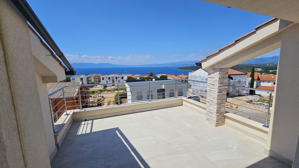 Dachterrasse mit Natursteinsäule und Blick über den Ort zur Bucht