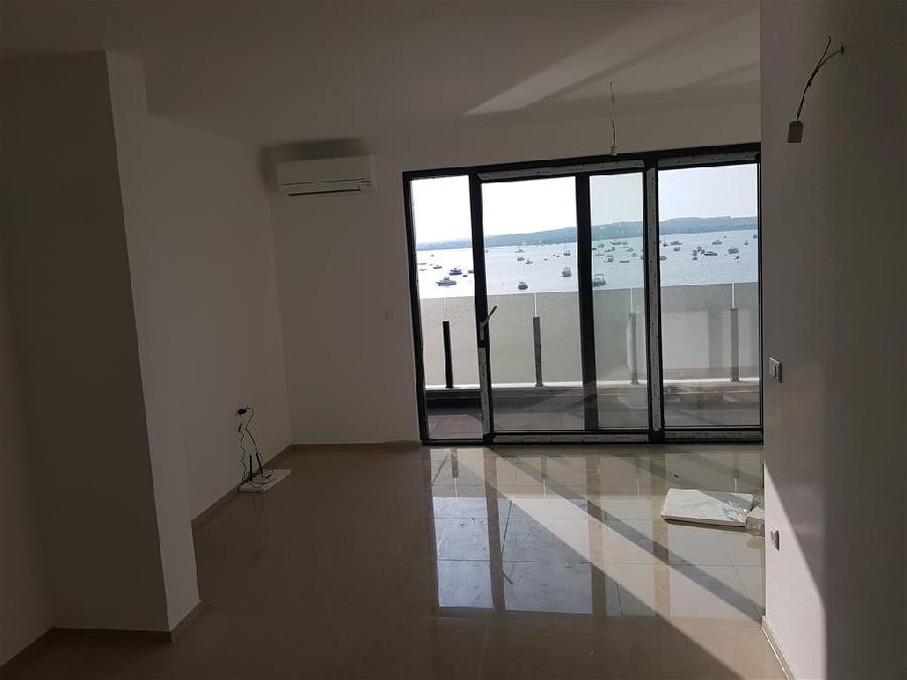 Wohn-Esszimmer des Apartments am Meer zum Kauf in Istrien, Kroatien - und der Blick auf Terrasse und Meer.